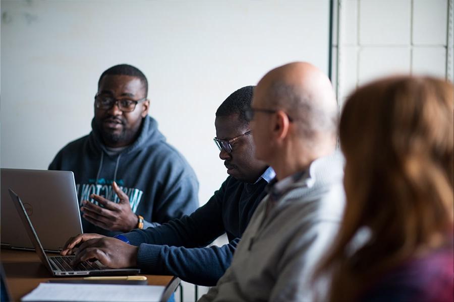 Students talk in a seminar sitting around a table.